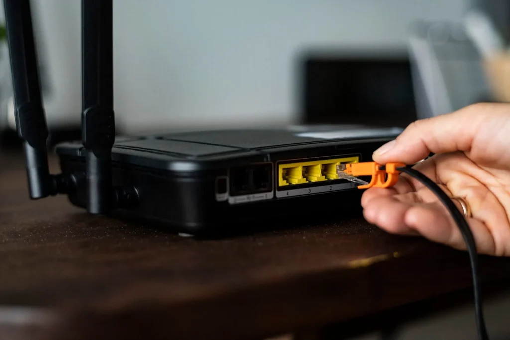 Technician connecting Ethernet cable to network switch for point to point wireless bridge setup
